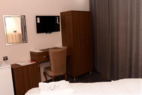a bedroom with a bed and a desk and a mirror at New Sirius Otel in Seyhan