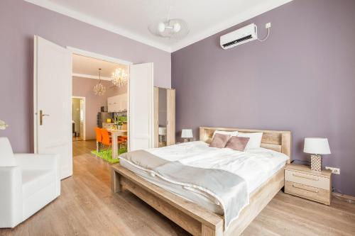 ein Schlafzimmer mit einem großen weißen Bett und einem Tisch in der Unterkunft Two Couples Apartment in Budapest