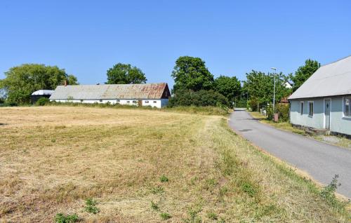 an empty road next to a farm building at 2 Bedroom Stunning Home In Simrishamn in Simrishamn