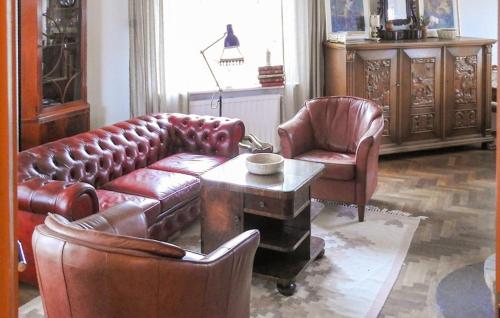 a living room with a leather couch and two chairs at 3 Bedroom Awesome Home In Lessebo in Lessebo