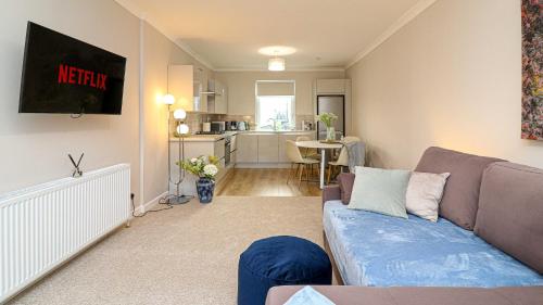 a living room with a couch and a kitchen at Modern And Cozy Apex Apartment in Helensburgh