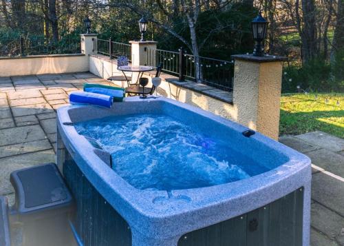 a large blue bath tub with a fountain at Acorns with own hot tub, romantic escape, close to Lyme Regis in Uplyme