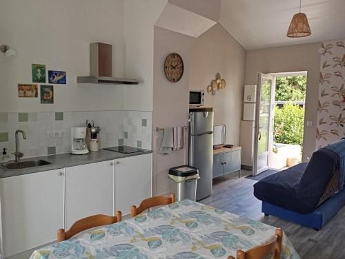 a kitchen with a table and a blue couch at Gite Le Gripeau in Apremont