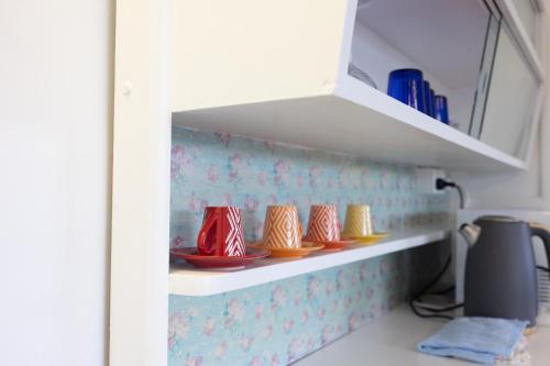 a shelf with red and yellow dishes in a kitchen at Zen Escape Guest House " Location 1" - Three listings - Romantic Escape, Cozy Delight, Oasis Suite in Brisbane
