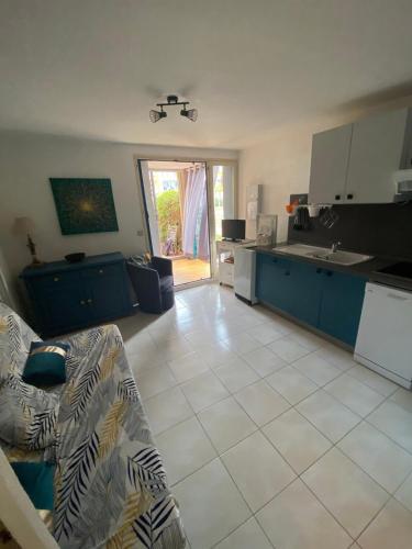 un salon avec un canapé et une cuisine dans l'établissement Cap de Mer Appart-4 pers, front de mer terrasse, au Barcarès