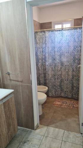 a bathroom with a toilet and a glass shower door at Brisas Rumipal dúplex premium Villa Rumipal in Villa Rumipal