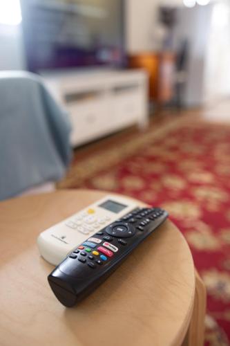 a remote control sitting on top of a table at Zen Escape Guest House " Location 1" - Three listings - Romantic Escape, Cozy Delight, Oasis Suite in Brisbane