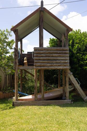 a wooden gazebo with a boat in the grass at Zen Escape Guest House " Location 1" - Three listings - Romantic Escape, Cozy Delight, Oasis Suite in Brisbane