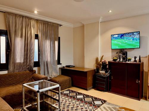 a living room with a couch and a flat screen tv at Akh Pyramid Hostel in Cairo