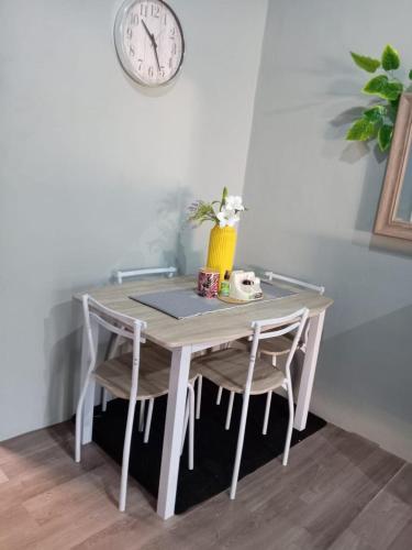 a table with two chairs and a clock on the wall at Hermosa Casa Peatonal Las Campanas in Tegucigalpa