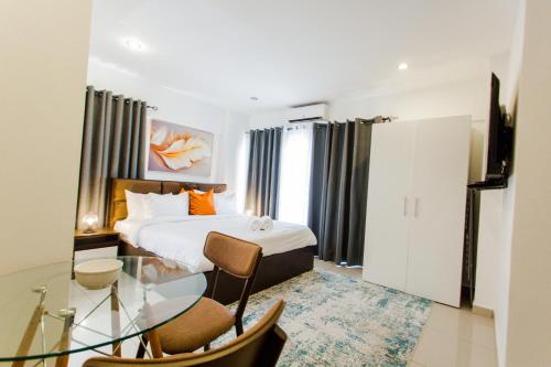 a hotel room with a bed and a glass table at Accra Luxury Apartments at The Gallery in Accra