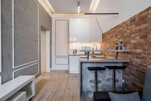 a kitchen with a brick wall and a counter with stools at Rynek 2B - Old Town in Wrocław