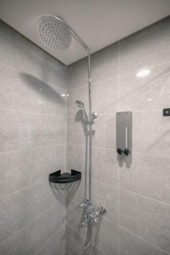 a shower with a glass door in a bathroom at 沐樂旅舍 MLbnb 南投集集 包棟民宿 in Jiji