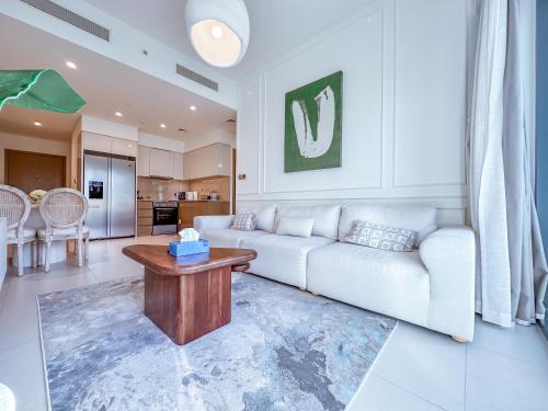 a living room with a white couch and a table at Spectacular Burj Khalifa View, 2BR Luxury Apartment by SBH in Dubai