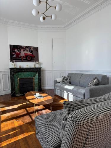 ein Wohnzimmer mit Sofa und Kamin in der Unterkunft L'écrin des Tanneurs - 110m2 - 2 chambres - Epernay Hyper Centre in Épernay