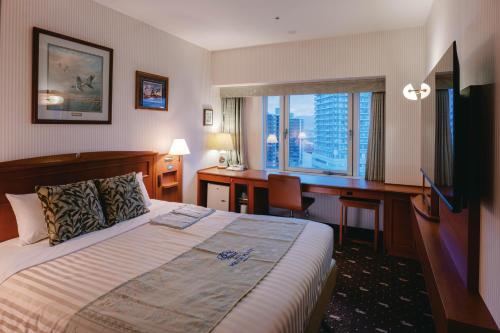 a hotel room with a bed and a desk at Hotel Boston Plaza Kusatsu in Kusatsu