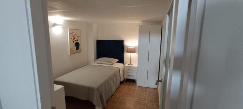 ein kleines Schlafzimmer mit einem Bett und einer Lampe in der Unterkunft Apartamento VILLASUR in Alcalá de los Gazules