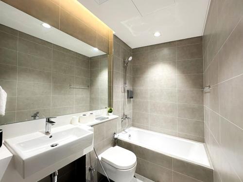 ドバイにあるLuxury 1BR with Aquatic View, District Oneの洗面台、トイレ、浴槽を備えたバスルーム