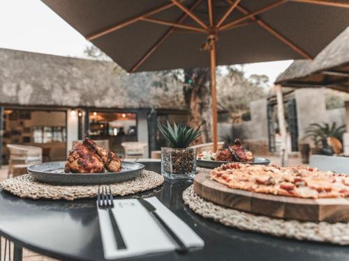 a table with two plates of food on it at Thaba eNtle Private Boutique Game Farm in Thabazimbi