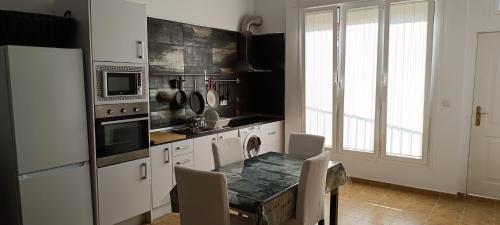 eine Küche mit Tisch und Kühlschrank in der Unterkunft Apartamento VILLASUR in Alcalá de los Gazules