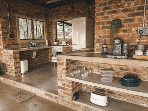 a kitchen with a brick wall and a counter top at Thaba eNtle Private Boutique Game Farm in Thabazimbi