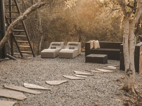 a garden with two couches and a tree at Thaba eNtle Private Boutique Game Farm in Thabazimbi