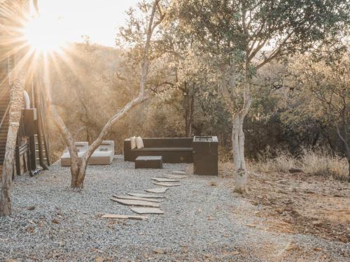 a park with a bench and a piano and trees at Thaba eNtle Private Boutique Game Farm in Thabazimbi
