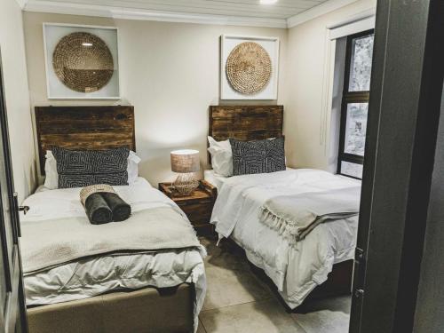 a bedroom with two beds and a table with a lamp at Thaba eNtle Private Boutique Game Farm in Thabazimbi
