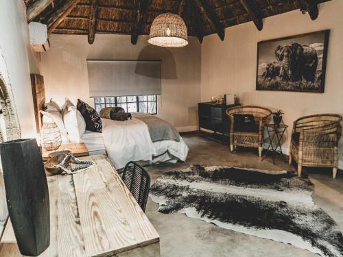 a bedroom with a bed and a table and chairs at Thaba eNtle Private Boutique Game Farm in Thabazimbi