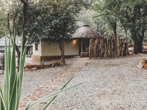 a house with a thatched roof and a path leading to a yard at Thaba eNtle Private Boutique Game Farm in Thabazimbi