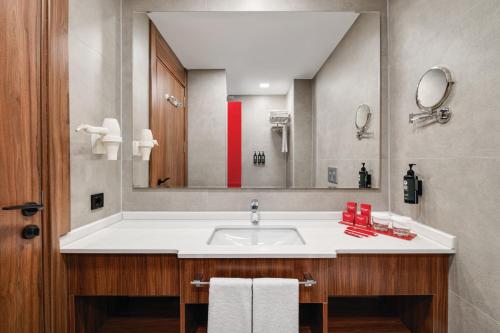 a bathroom with a sink and a large mirror at Ramada by Wyndham Gaziantep in Gaziantep