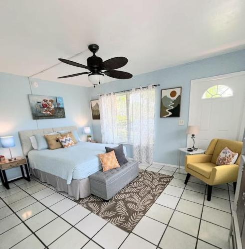 a bedroom with a bed and a couch and a ceiling fan at BEACH Zen Oasis-walk 2 beaches in Deerfield Beach