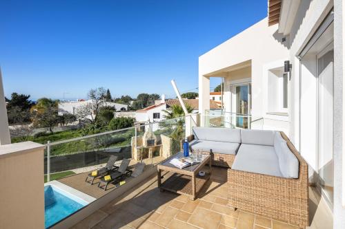 a patio with a couch and a table on a balcony at Villa Rosati in Carvoeiro