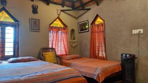 a bedroom with two beds in a room at Perch Villa Homestay in Shānti Niketan