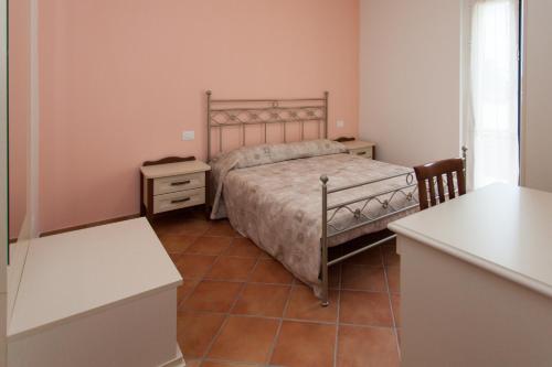 a small bedroom with a bed and two night stands at Venticello Del Conero in Gli Angeli