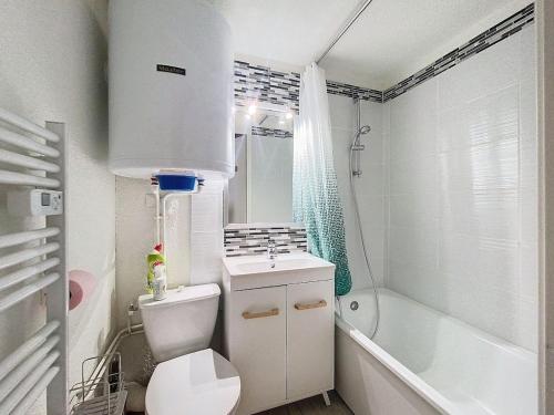 een badkamer met toilet, wastafel en bad bij Charming duplex in La Toussuire