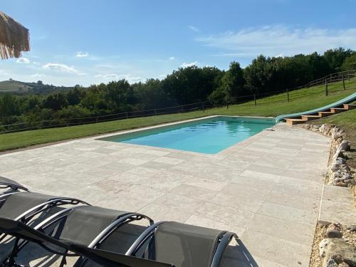 - une piscine avec des chaises dans l'arrière-cour dans l'établissement L’effet vacances, à Saint-Pastour