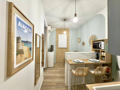 une cuisine avec une table et des chaises dans une pièce dans l'établissement Le cocon du Roi Jérôme - Hypercentre, à Ajaccio