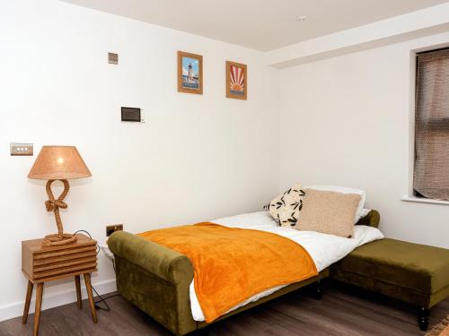 a bedroom with a bed and a green couch at Stylish Seaside Stay - Spacious Ramsgate Apartment - New Build, Underfloor Heating, Perfect Location in Ramsgate
