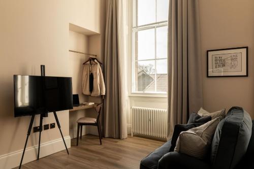 a living room with a tv and a chair and a window at Moment George IV Bridge in Edinburgh