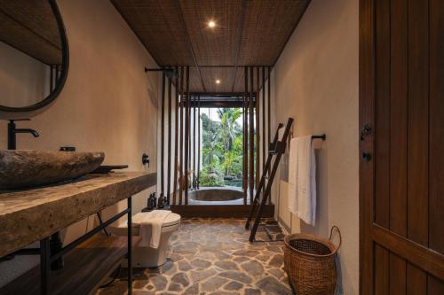 a bathroom with a sink and a bath tub at SHIBUMI - Private Pool & Spa Boutique Villa in Ubud