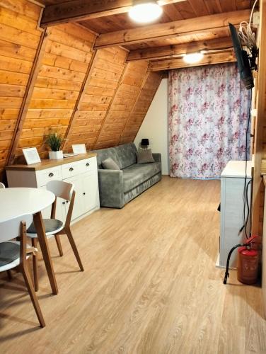 a living room with a couch and a table at Domek na Mazurach Leśne Zacisze in Ostaszewo