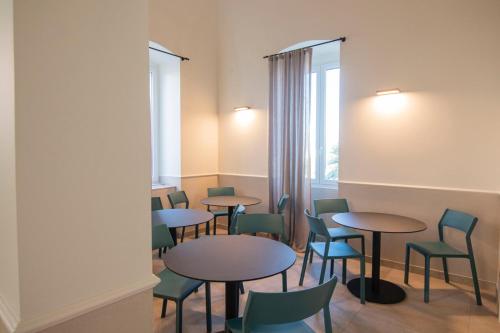 een kamer met tafels en stoelen en een raam bij Villa Emy Boutique Bed & Breakfast in Bisceglie