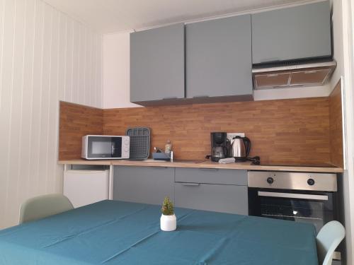 une cuisine avec une table et un chiffon bleu dans l'établissement Au Citron Vert en hyper centre ville, à Cholet