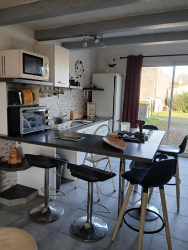 une cuisine avec une table et quelques chaises dans l'établissement Dorian, à Pornic