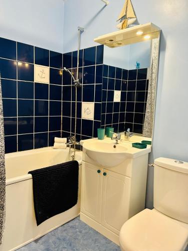 une salle de bain avec un lavabo, une baignoire et des toilettes dans l'établissement Studio une brise marine, à Trouville-sur-Mer