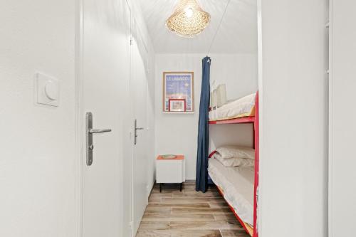 ein kleines Zimmer mit einem Etagenbett und einem Schrank in der Unterkunft Appartement Le Lavandou - Cavalière in Le Lavandou