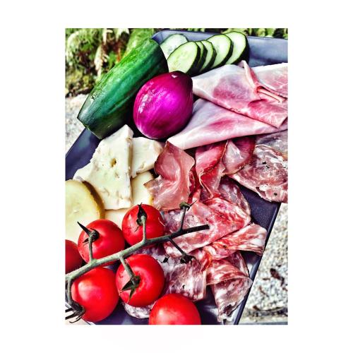 a plate of food with tomatoes and other vegetables at Villa Marrakesh Noszvaj in Noszvaj