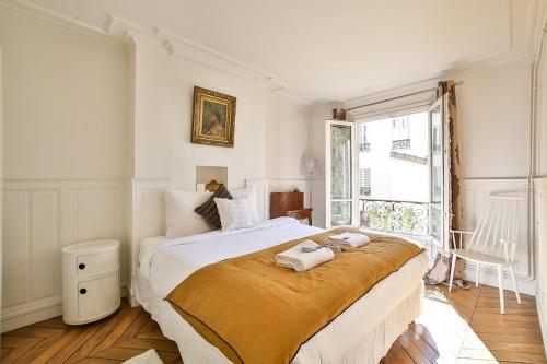 une chambre avec un grand lit avec deux serviettes dessus dans l'établissement L'artistique - design & spacieux - Tour Eiffel, à Paris