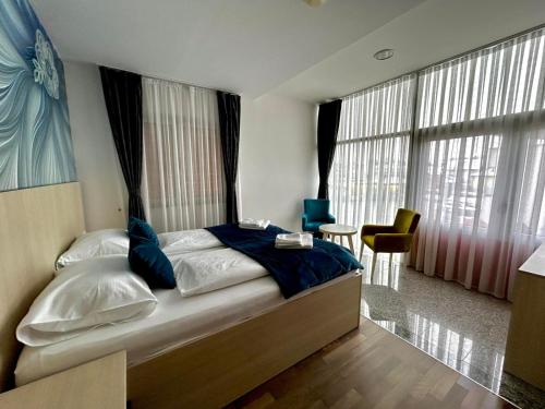 a bedroom with a large bed with blue pillows at Prenoćište Euro-Jet Ćoralići in Ćoralići